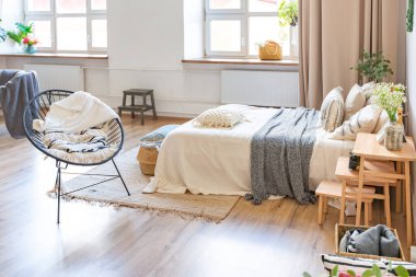 Şık bir çatı katının içinde. Geniş pencereli, yerde parke ve aydınlık duvarlı geniş bir daire. Dekorasyon için farklı küçük şeylerle rafların yakın görüntüsü