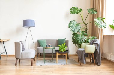 Şık bir çatı katının içinde. Geniş pencereli, yerde parke ve aydınlık duvarlı geniş bir daire. Dekorasyon için farklı küçük şeylerle rafların yakın görüntüsü