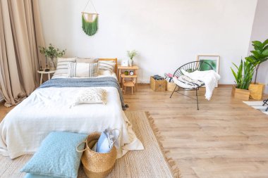 Şık bir çatı katının içinde. Geniş pencereli, yerde parke ve aydınlık duvarlı geniş bir daire. Dekorasyon için farklı küçük şeylerle rafların yakın görüntüsü