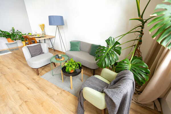 interior of stylish loft. spacious apartment with large windows, parquet on the floor and light walls. closeup view of shelving with different small things for decoration
