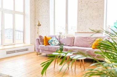 İskandinav tarzı bir daire. parlak sarı sıcak renkler. Ahşap döşeme. Büyük pencerelerde güneş ışığı.