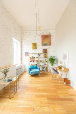 Çatı katı tarzında çalışmanın içerisi. Tuğla duvar Ahşap döşeme. Oturma alanı olan büyük, parlak bir oda. kanepe ve piyano
