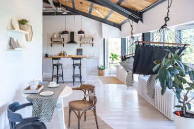 Şık mutfak iç tasarımı. Beyaz duvarlar ve ahşap süslemeler. Güzel hamak ve yüksek pencereler.