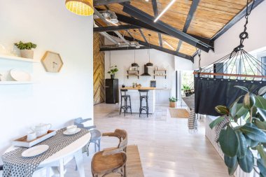 Şık mutfak iç tasarımı. Beyaz duvarlar ve ahşap süslemeler. Güzel hamak ve yüksek pencereler.