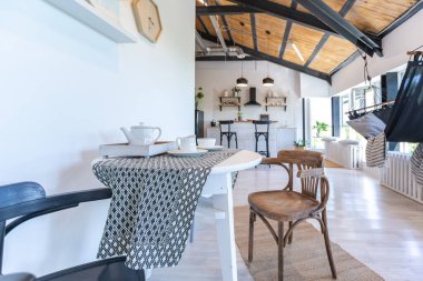 Şık mutfak iç tasarımı. Beyaz duvarlar ve ahşap süslemeler. Güzel hamak ve yüksek pencereler.