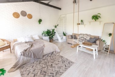 Minimalist tarzda bir kır evinde lüks yatak odası tasarımı. Beyaz duvarlar, panoramik pencereler, tavanda ahşap süslemeler, geniş bir odanın ortasında sallanan ip..