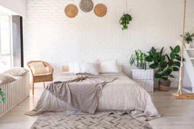 Minimalist tarzda bir kır evinde lüks yatak odası tasarımı. Beyaz duvarlar, panoramik pencereler, tavanda ahşap süslemeler, geniş bir odanın ortasında sallanan ip..