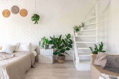 Minimalist tarzda bir kır evinde lüks yatak odası tasarımı. Beyaz duvarlar, panoramik pencereler, tavanda ahşap süslemeler, geniş bir odanın ortasında sallanan ip..