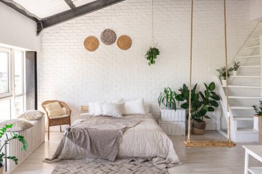 Minimalist tarzda bir kır evinde lüks yatak odası tasarımı. Beyaz duvarlar, panoramik pencereler, tavanda ahşap süslemeler, geniş bir odanın ortasında sallanan ip..