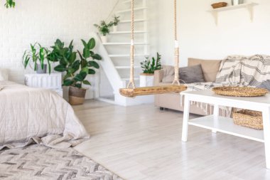 Minimalist tarzda bir kır evinde lüks yatak odası tasarımı. Beyaz duvarlar, panoramik pencereler, tavanda ahşap süslemeler, geniş bir odanın ortasında sallanan ip..