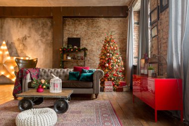 Çatı katı tarzındaki oturma odasının alışılmadık karanlık iç kısmı bir Noel ağacıyla süslenmiş.