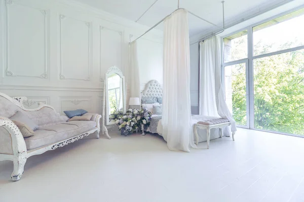 整洁的室内卧室和客厅 有一个大的全景窗户 漂亮的古董家具 一张四张床 一面镜子和一张沙发 — 图库照片