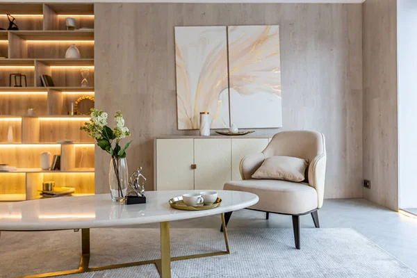 暖かい柔らかい色のスタジオアパートメントのリビングエリアのモダンなインテリアデザイン 装飾的な組み込みの照明や柔らかいベージュの家具 — ストック写真