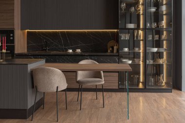 Lüks bir evin lüks bir iç mekanında, ahşap süslemeli koyu siyah ve kahverengi modern tasarımı olan bir mutfak.