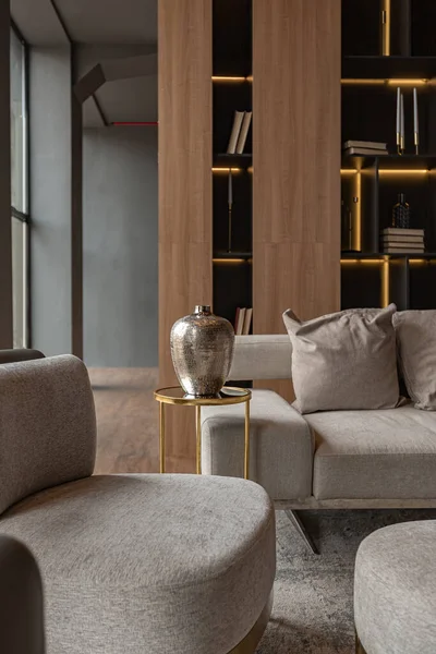 リビングルーム 大理石の壁の暖炉と金の要素を持つ光 灰色の家具を主導したモダンなデザインの高級カントリーハウスのシックな高価なインテリアでスタイリッシュな本棚 — ストック写真