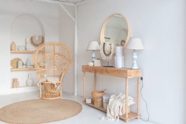 Beyaz duvarları, bambu koltuğu, büyük beyaz kanepesi ve süslemeleri olan Bali tarzı parlak bir dairenin içi.