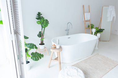 Modern banyo, yeşil bitkiler ve ahşap elementlerle donatılmış ekstra beyaz ve çok hafif minimalist zarif bir banyo.