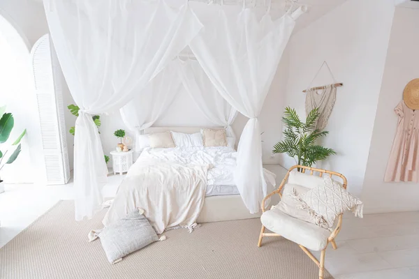 白い壁 竹の家具と明るいバリスタイルのアパートの居心地の良いインテリア ベッドルームにはナイトライト ベッドにはバランチンと大きな窓があり — ストック写真