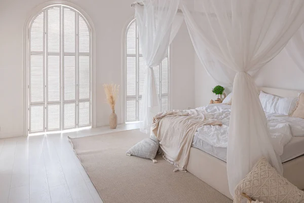 舒适的内部明亮的巴厘风格的公寓与白色的墙壁 竹子家具 有夜灯的卧室 有天平和大窗户的床 — 图库照片