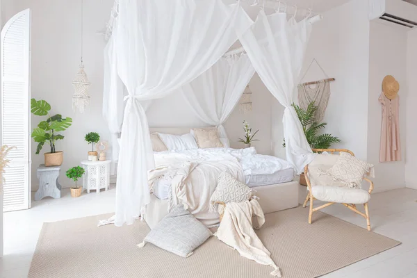白い壁 竹の家具と明るいバリスタイルのアパートの居心地の良いインテリア ベッドルームにはナイトライト ベッドにはバランチンと大きな窓があり — ストック写真