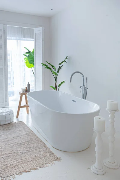 stock image Extra white and very light minimalistic stylish elegant interior of bathroom with modern bath, green plants and wooden elements