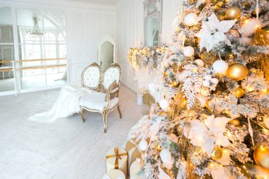 Lüks, pahalı, aydınlık bir oturma odası. Noel ağacı ve büyük pencerelerle süslenmiş kraliyet tarzı.