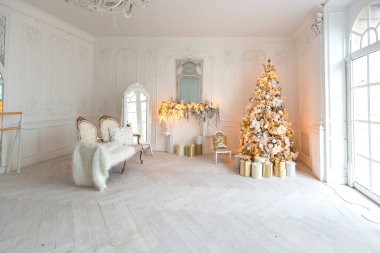 Lüks, pahalı, aydınlık bir oturma odası. Noel ağacı ve büyük pencerelerle süslenmiş kraliyet tarzı.