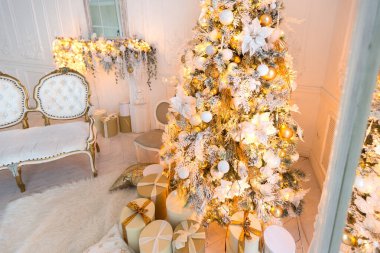 Lüks, pahalı, aydınlık bir oturma odası. Noel ağacı ve büyük pencerelerle süslenmiş kraliyet tarzı.