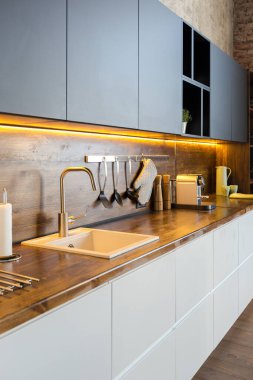 Lüks bir stüdyo daire. Koyu renkli, tavan arası tarzı bedava bir düzen. Adayı olan modern mutfak alanı şöminesi ve spor salonu olan rahat yatak odası.