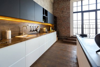 Lüks bir stüdyo daire. Koyu renkli, tavan arası tarzı bedava bir düzen. Adayı olan modern mutfak alanı şöminesi ve spor salonu olan rahat yatak odası.