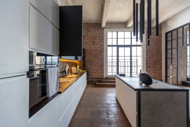 Lüks bir stüdyo daire. Koyu renkli, tavan arası tarzı bedava bir düzen. Adayı olan modern mutfak alanı şöminesi ve spor salonu olan rahat yatak odası.