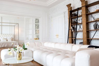 Lüks, büyük, iki odalı, modern bir apartman dairesi. Beyaz duvarlar, lüks pahalı mobilyalar, parke döşemeler ve beyaz iç kapılar.