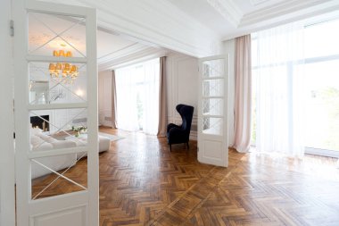 Lüks, büyük, iki odalı, modern bir apartman dairesi. Beyaz duvarlar, lüks pahalı mobilyalar, parke döşemeler ve beyaz iç kapılar.