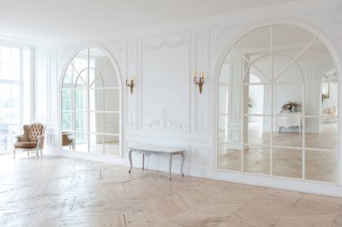 Pahalı antika mobilyaları olan büyük, şık bir salon. Barok iç tasarımı, duvarlarda süs ve yerde parke var..