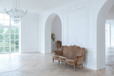 Pahalı antika mobilyaları olan büyük, şık bir salon. Barok iç tasarımı, duvarlarda süs ve yerde parke var..