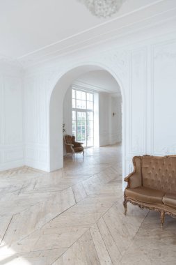 Pahalı antika mobilyaları olan büyük, şık bir salon. Barok iç tasarımı, duvarlarda süs ve yerde parke var..