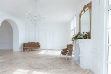 Pahalı antika mobilyaları olan büyük, şık bir salon. Barok iç tasarımı, duvarlarda süs ve yerde parke var..