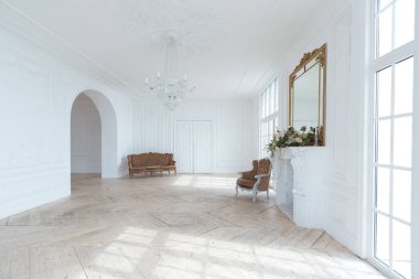 Pahalı antika mobilyaları olan büyük, şık bir salon. Barok iç tasarımı, duvarlarda süs ve yerde parke var..