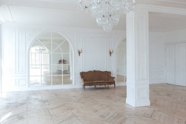 Pahalı antika mobilyaları olan büyük, şık bir salon. Barok iç tasarımı, duvarlarda süs ve yerde parke var..