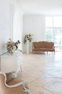 Pahalı antika mobilyaları olan büyük, şık bir salon. Barok iç tasarımı, duvarlarda süs ve yerde parke var..