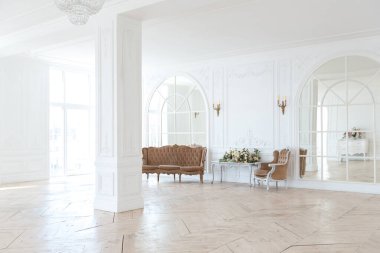 Pahalı antika mobilyaları olan büyük, şık bir salon. Barok iç tasarımı, duvarlarda süs ve yerde parke var..