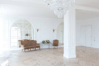 Pahalı antika mobilyaları olan büyük, şık bir salon. Barok iç tasarımı, duvarlarda süs ve yerde parke var..