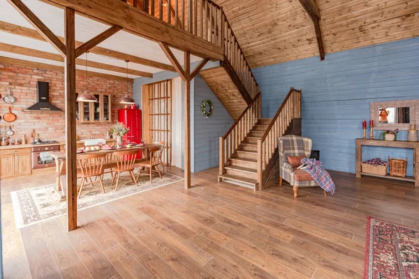 stock image cozy all wooden interior of a country house in a wooden design. spacious living room with kitchen area with large windows. bedroom on the second floor.