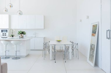 Minimalist tarzda pahalı mobilyaları olan ekstra beyaz renkli bir stüdyo dairenin lüks modern iç tasarımı. beyaz fayanslı zemin, mutfak, rahatlama alanı ve işyeri