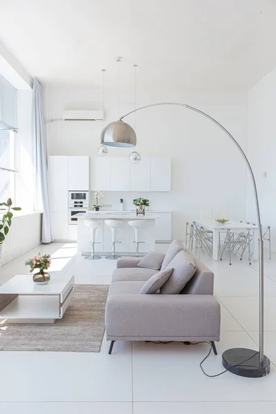ミニマリストスタイルでファッショナブルな高価な家具と余分な白い色のスタジオアパートの居心地の良い豪華な近代的なインテリアデザイン 白いタイル張りの床 キッチン リラクゼーションエリア — ストック写真