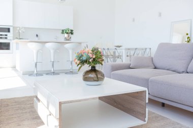 Minimalist tarzda pahalı mobilyaları olan ekstra beyaz renkli bir stüdyo dairenin lüks modern iç tasarımı. beyaz fayanslı zemin, mutfak, rahatlama alanı ve işyeri