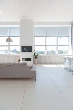 Minimalist tarzda pahalı mobilyaları olan ekstra beyaz renkli bir stüdyo dairenin lüks modern iç tasarımı. beyaz fayanslı zemin, mutfak, rahatlama alanı ve işyeri