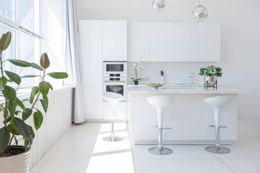 Minimalist tarzda pahalı mobilyaları olan ekstra beyaz renkli bir stüdyo dairenin lüks modern iç tasarımı. beyaz fayanslı zemin, mutfak, rahatlama alanı ve işyeri