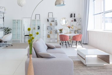 Minimalist tarzda pahalı mobilyaları olan ekstra beyaz renkli bir stüdyo dairenin lüks modern iç tasarımı. beyaz fayanslı zemin, mutfak, rahatlama alanı ve işyeri