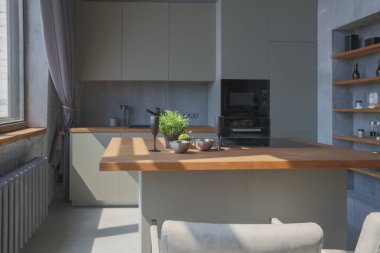 Modern minimalist koyu gri çatı katı tarzı stüdyo daire iç tasarımı. Mutfak, oturma odası, iş yeri, duş ve banyo. İçerideki parlak güneş ışınları.